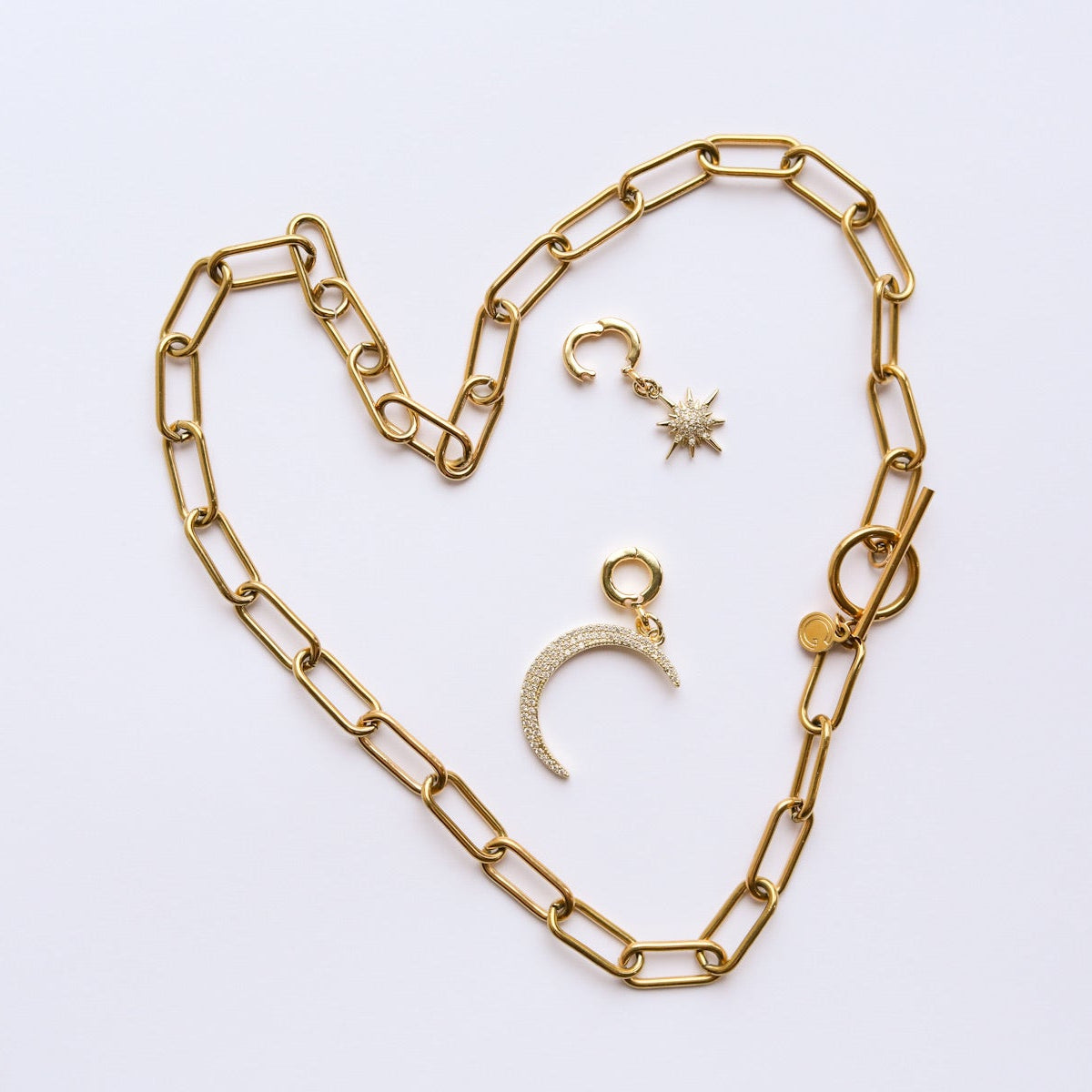 Gold chain necklace and charms with locks on a white background