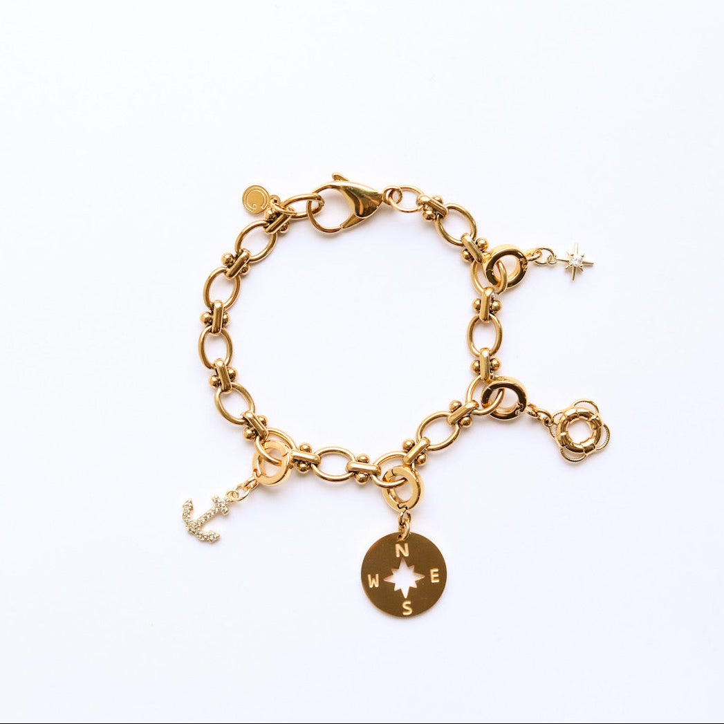 Gold bracelet with charms on a white background